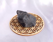 Charger l'image dans la galerie, Pierre brute d’onyx posée sur une fleur de vie en bois pour recharger ses énergies protectrices.